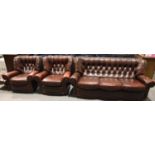 Three piece red leather Chesterfield type suite with button backs, comprising two armchairs and a