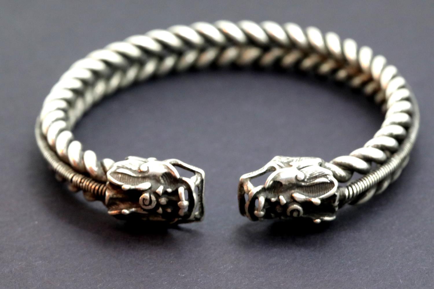 White metal Tibetan silver twisted rope effect bangle with dragon head decoration. 38g. P&P Group 1