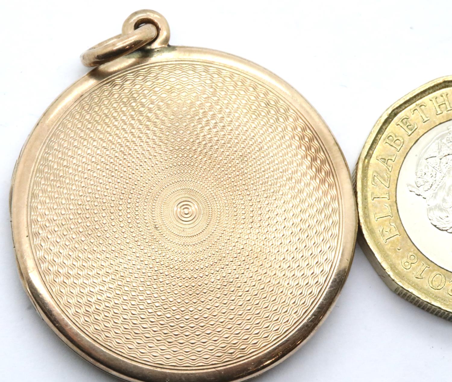 Presumed 9ct gold circular locket with machine turned decoration, unmarked, D: 31 mm, 10.7g. P&P