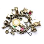 Silver charm bracelet with twenty four charms, 86g. P&P Group 1 (£14+VAT for the first lot and £1+