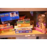 Shelf of mixed children's toys and games including Disney Rapunzel styling head. Not available for