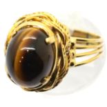 Presumed gold unmarked tigers eye set ring, 7.5g, size O. P&P Group 1 (£14+VAT for the first lot and