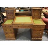Victorian oak Dickens style desk with fifteen drawers and lifting centre section to fitted interior,