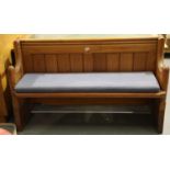 20th century pitch pine short pew, L: 135 cm, with cushioned seat cover. Not available for in-