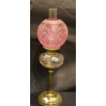 Victorian brass columnar oil lamp with Cranberry glass shade, H: 90 cm. Not available for in-house