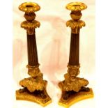 A pair of Regency bronze and gilt bronze candlesticks, decorated with acanthus leaf form drip