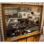 A large modern gilt framed wall mirror with bevelled glass, overall 135 x 106 cm. This lot is sold