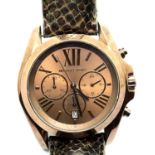 Brown metallic dial Michael Kors large wristwatch on a leather strap. P&P Group 1 (£14+VAT for the