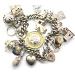 Sterling silver charm bracelet with sixteen charms, 68g. P&P Group 1 (£14+VAT for the first lot