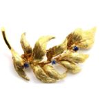 18ct gold pin brooch, floral design set with three small sapphires, 5.5g. P&P Group 1 (£14+VAT for