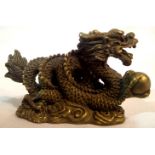 Brass Oriental dragon with ball, L: 65 mm. P&P Group 1 (£14+VAT for the first lot and £1+VAT for