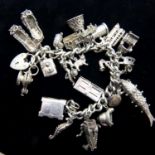 Heavy silver charm bracelet with twenty charms, 123g. P&P Group 1 (£14+VAT for the first lot and £