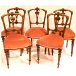 Five Victorian walnut framed upholstered dining chairs on turned and tapered supports. Not available