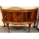 A 20th century walnut four door sideboard in the Epstein style, raised on claw and ball supports,