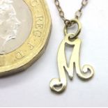 14ct gold letter M pendant on a 12ct gold chain, combined 1.3g. P&P Group 1 (£14+VAT for the first