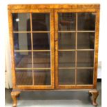 1930s walnut two door glazed bookcase with three shelves, retailers label inside Harrods London,