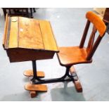 A Late 19th/ early 20th century pine students desk with incorporated chair and cast iron cross