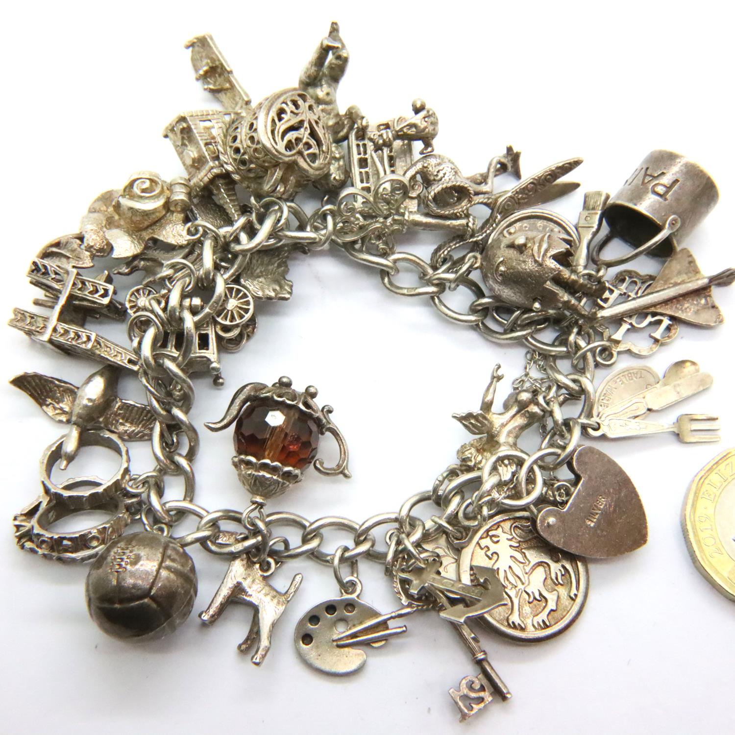 925 silver charm bracelet with padlock clasp and 29 charms, combined 91g. P&P Group 1 (£14+VAT for