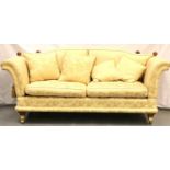 A substantial cream upholstered 20th Century Knoll drop-end sofa, raised on large brass castors, 220