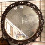 A bevelled edge Victorian wall mirror within a carved oak frame, D: 63 cm. Not available for in-