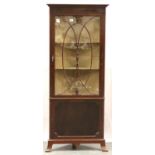 An Edwardian corner cupboard, free standing with single glazed display door, two shelves and