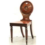 A Regency mahogany hall chair, the circular back rest with painted initial, raised on turned and