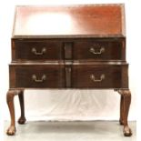 An Edwardian mahogany fall-front bureau with fitted interior above two shaped long drawers, raised