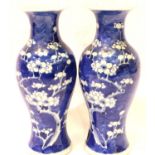 Pair of Chinese blue and white Prunus decorated flared neck vases with two flea bites to one rim, H: