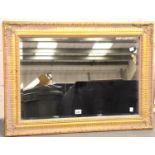 A large gilt framed bevelled edged wall mirror, 94 x 68 cm. Not available for in-house P&P,