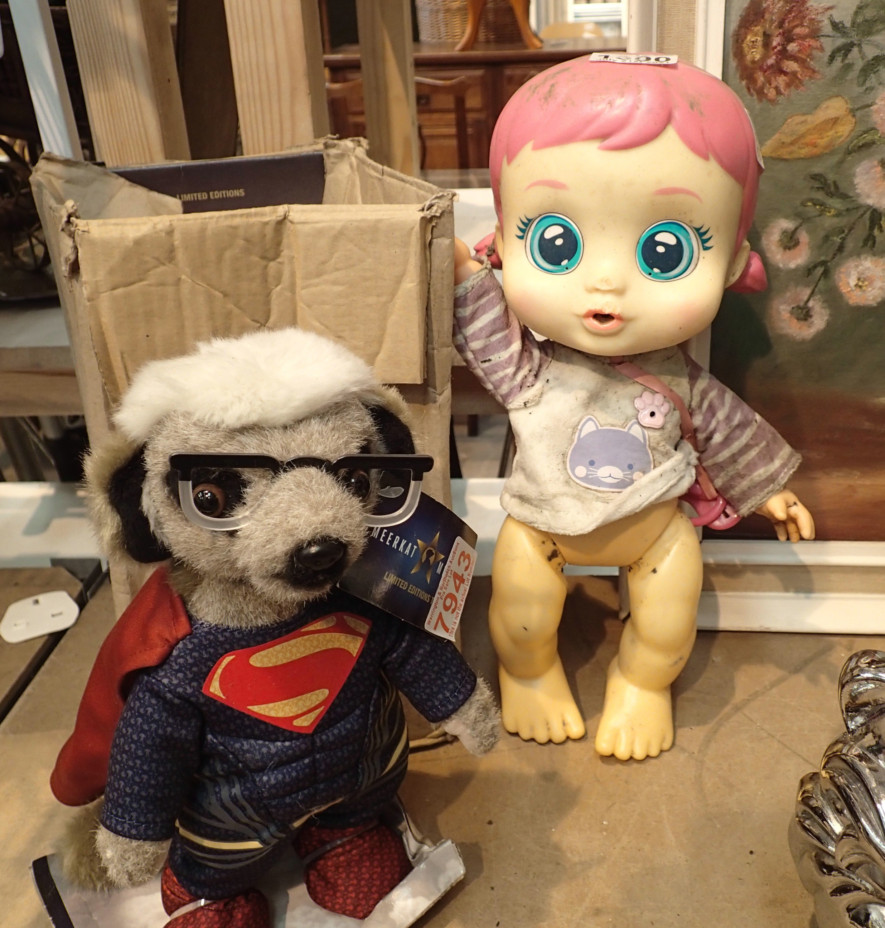 Superman Meerkat and a doll. Not available for in-house P&P, contact Paul O'Hea at Mailboxes on