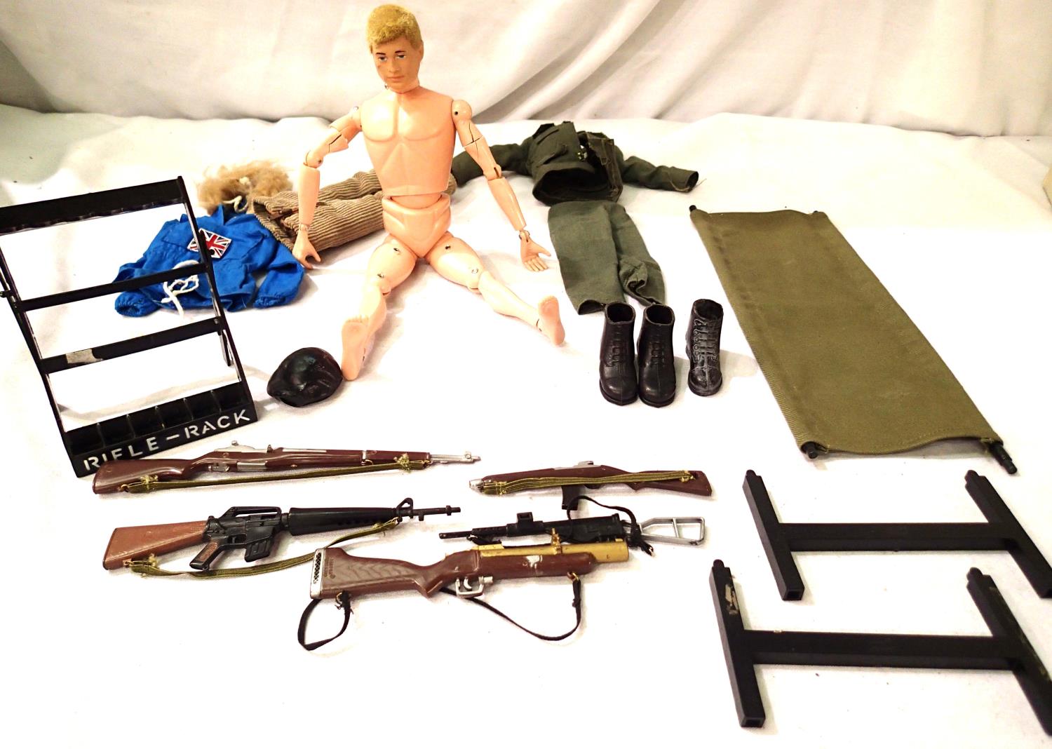 Action Man, flock hair c1964, cracks on arms and legs, also includes five rifles with rack,