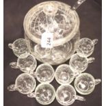 An early 20th century cut glass punch bowl with cover, glass ladle and ten punch cups. Not available
