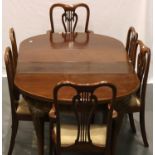 A 20th century walnut dining table with two drop in leaves, ball and claw feet with six chairs (4+