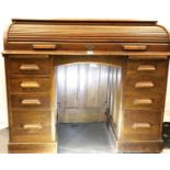 A Victorian oak roll-top desk, the tambour cover encloses a fitted interior of drawers and pigeon