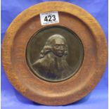 Circular bronzed plaque of man in a circular oak frame, D: 23 cm. P&P Group 1 (£14+VAT for the first