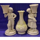 Pair of Belleek boy and girl candlesticks and a Belleek vase. P&P Group 3 (£25+VAT for the first lot