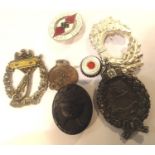 Four replica German WWII badges including an enamelled Hitler Youth example, together with a brass