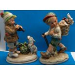 Two figurines in the Hummel/Goebel style, including Boy playing flute to dog and one other, H: 15