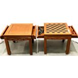 An Oriental hardwood games compendium table with two drawers, thirty-two piece chess set, chess