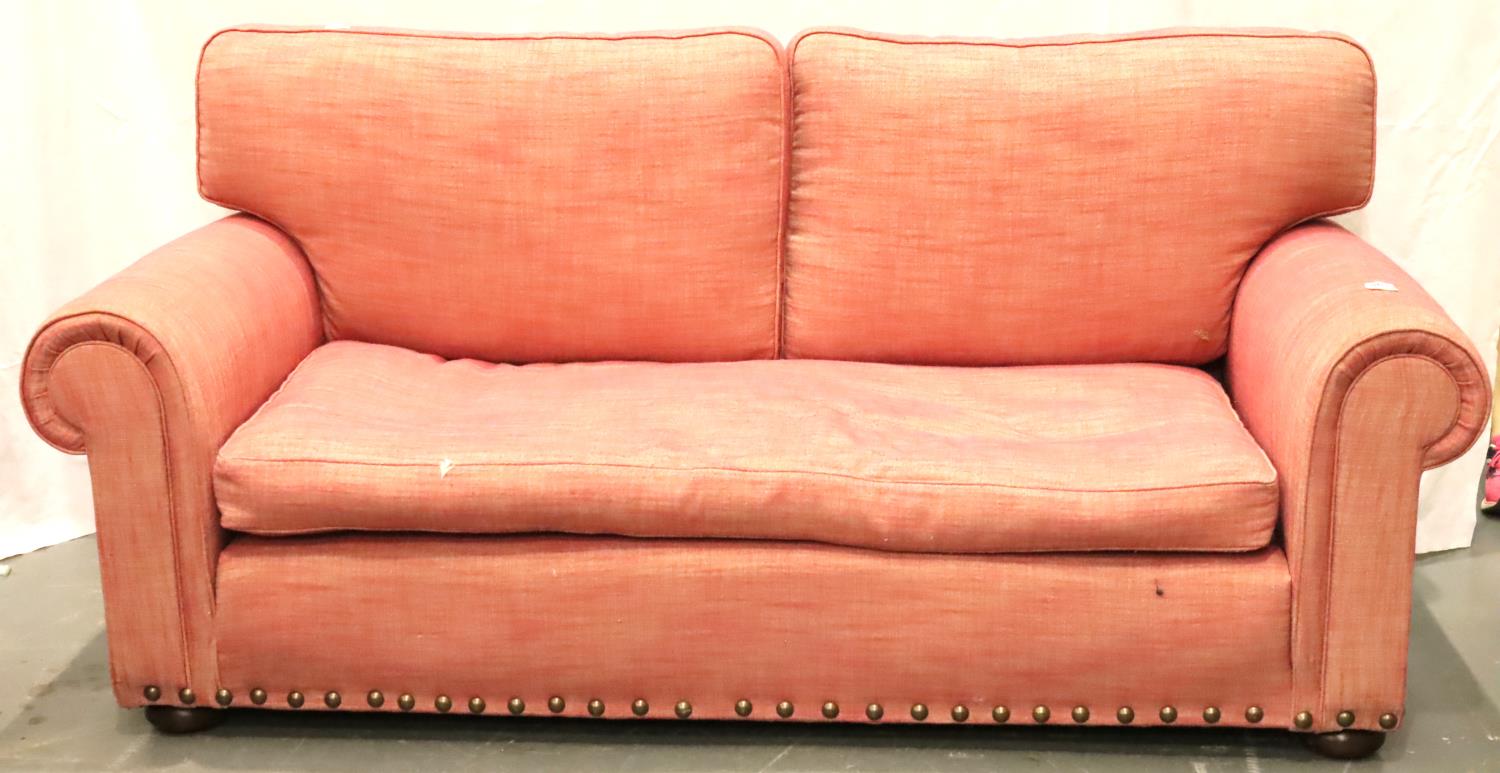 A contemporary two seat sofa with studs and upholstered in pink, L: 200 cm. Not available for in-