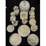 Belleek; eighteen pieces, cups, saucers, biscuit barrel, clock, vases, jugs, bowls with green and