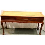A contemporary three drawer console table in Oriental hardwood with carved hand pulls, 152 x 52 x 84