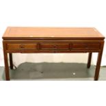 A contemporary three drawer console table in oriental hardwood with carved hand pulls, 153 x 52 x 84
