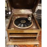 Wooden cased Columbia record player with small quantity of 78 rpm records and a tin of needles.