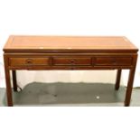 A contemporary three drawer console table in Oriental hardwood with carved hand pulls, 153 x 52 x 84