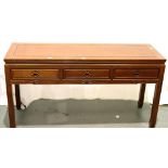 A contemporary three drawer console table in Oriental hardwood with carved hand pulls, 153 x 52 x 84