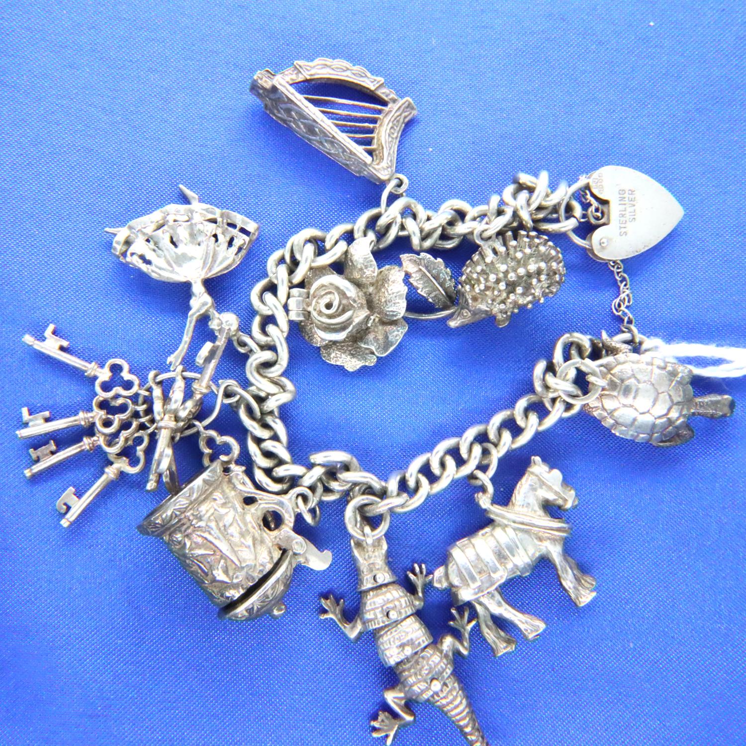 Sterling silver charm bracelet, nine charms, L: 18 cm, 55g. P&P Group 2 (£18+VAT for the first lot - Image 2 of 2