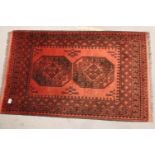 Red ground woollen fringed rug with three decorative panels, 130 x 54 cm. Not available for in-house