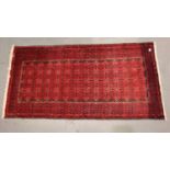 Red ground fringed woollen rug, 200 x 100 cm. Not available for in-house P&P, contact Paul O'Hea