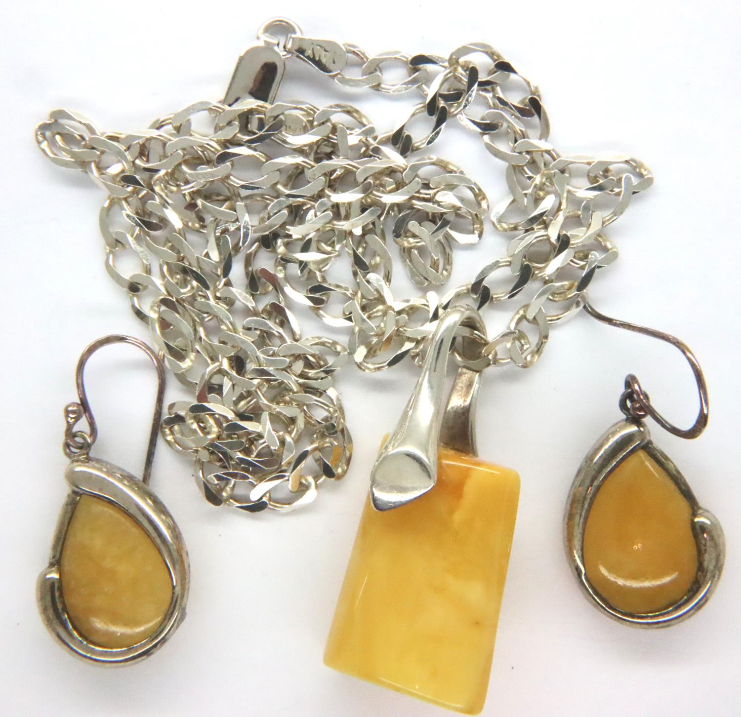 A silver butterscotch amber set pendant and necklace and earrings. Chain L: 60 cm, earring L: 30 mm.